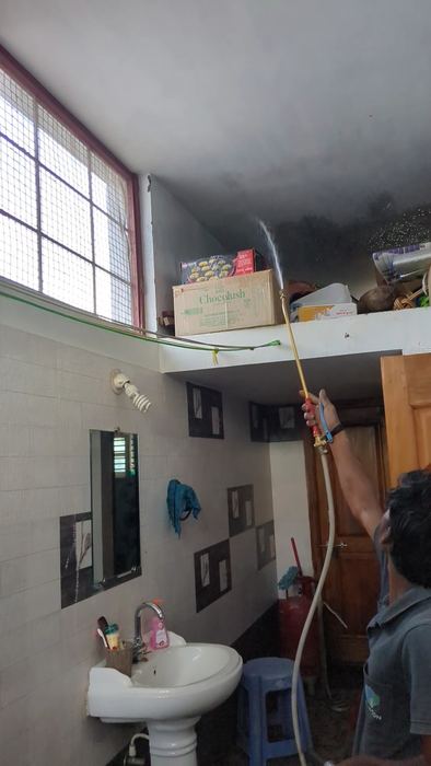 Technician spraying a bathroom ceiling and walls