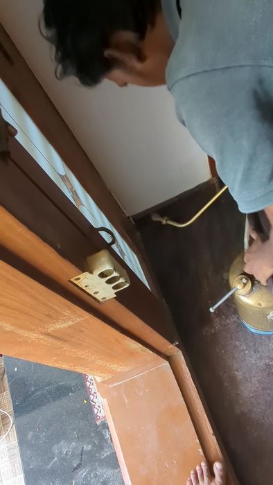 Technician spraying a wooden door frame